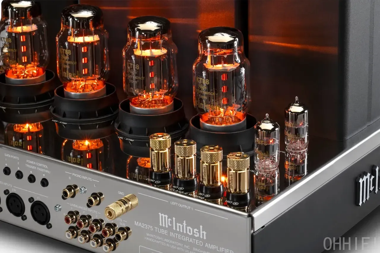 Close-up of the McIntosh MA2375 tube amplifier's glowing KT88 and 12AT7 tubes, gold binding posts and rear input panel