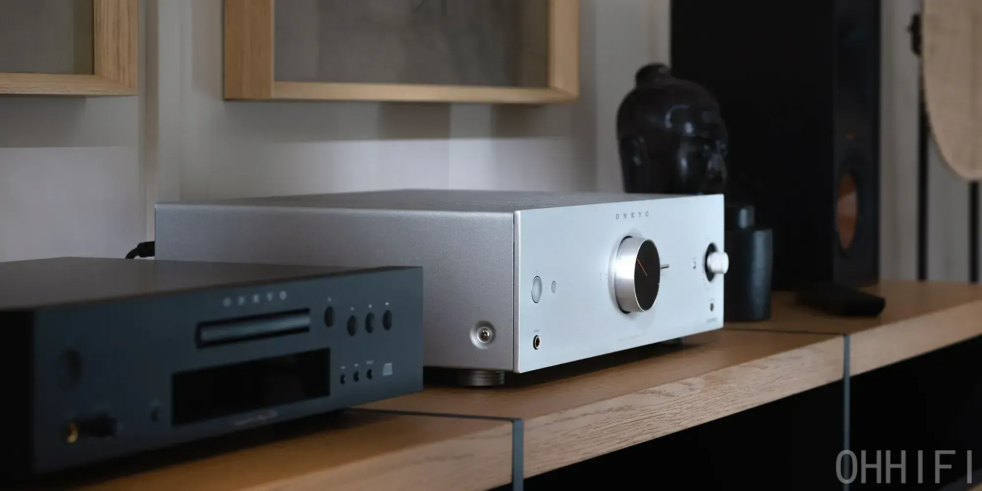 Silver Onkyo Icon A-50 amplifier on an oak shelf beside a black Onkyo CD player, with a speaker in the background