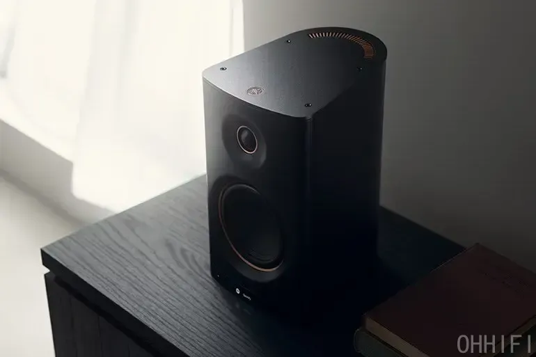 Single black Yamaha NX-70A speaker on a wooden cabinet, top-down angle showing aluminum plate and copper vent detail